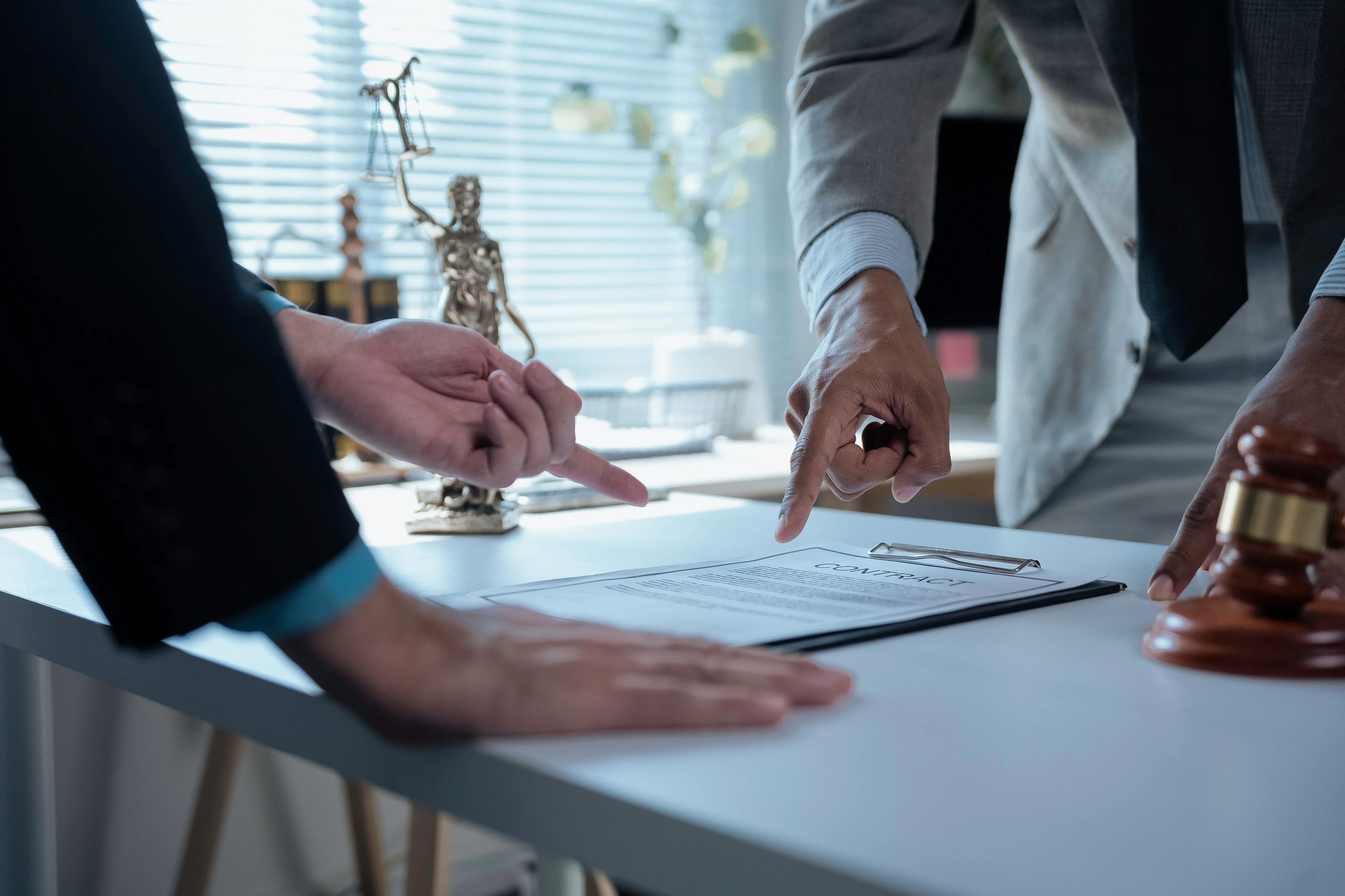 Legal professionals examine a contract in a law office.